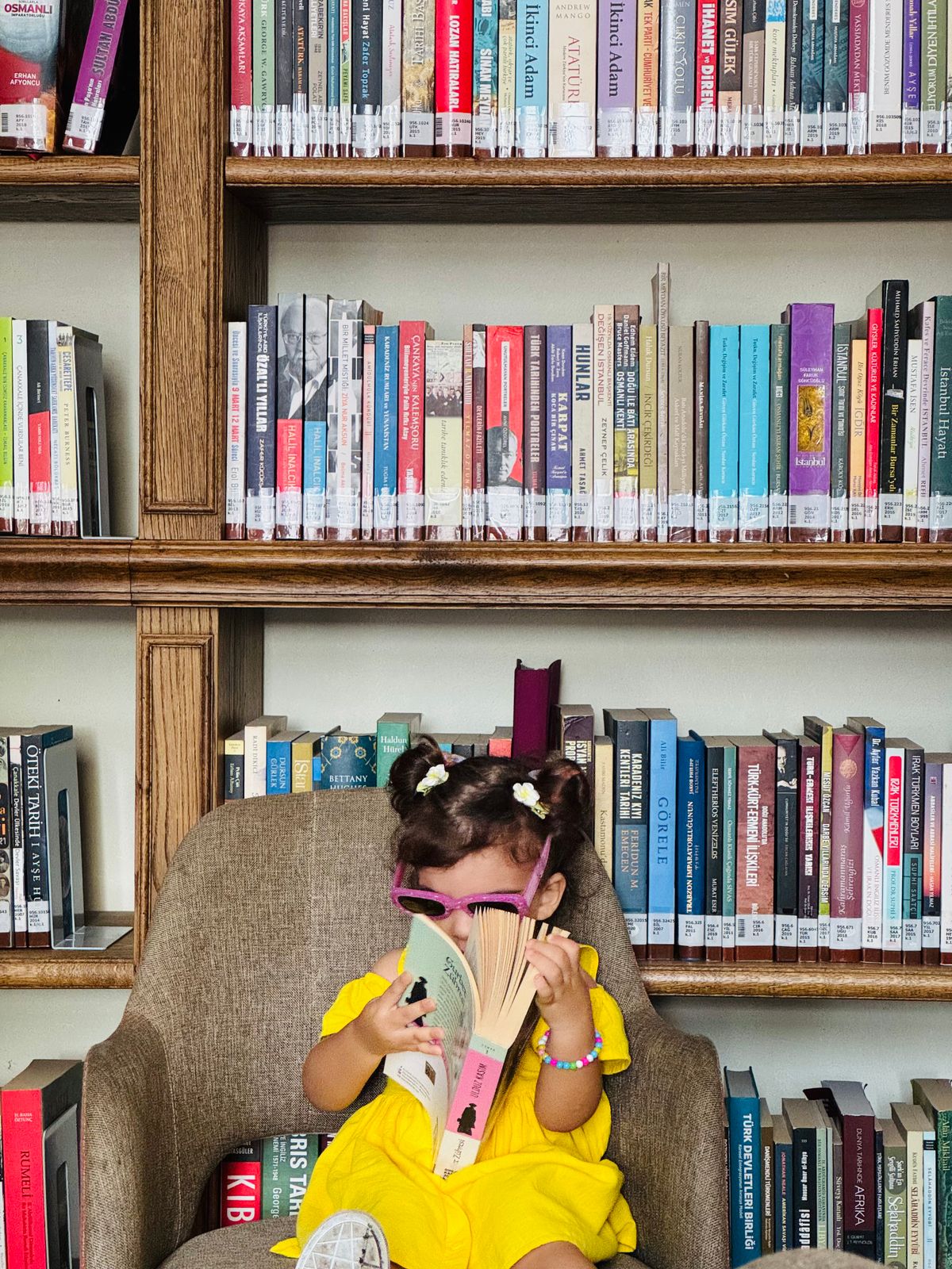 Toddler girl picking a picture book off a low shelf