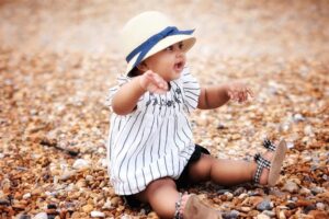 Toddler sitting outdoors wearing sandals