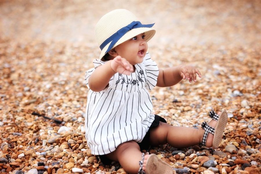 Toddler sitting outdoors wearing sandals