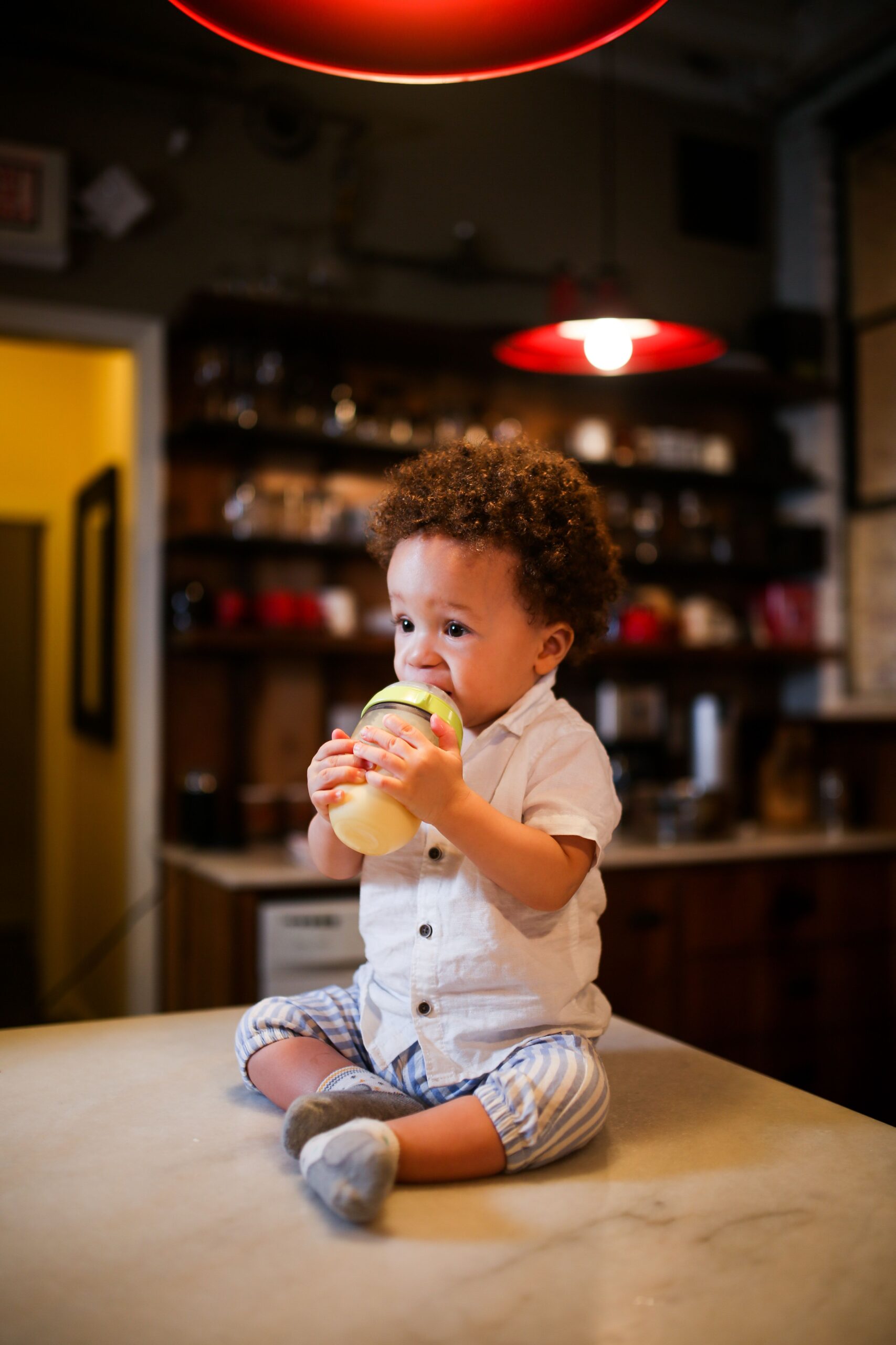 Best straw cups for toddlers: an infant holding and drinking from a cup independently