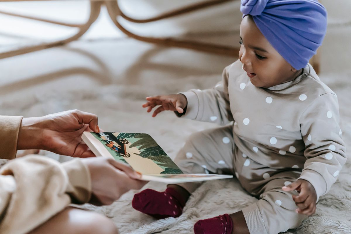 Best board books for toddlers: a toddler holding and reading a sturdy board book