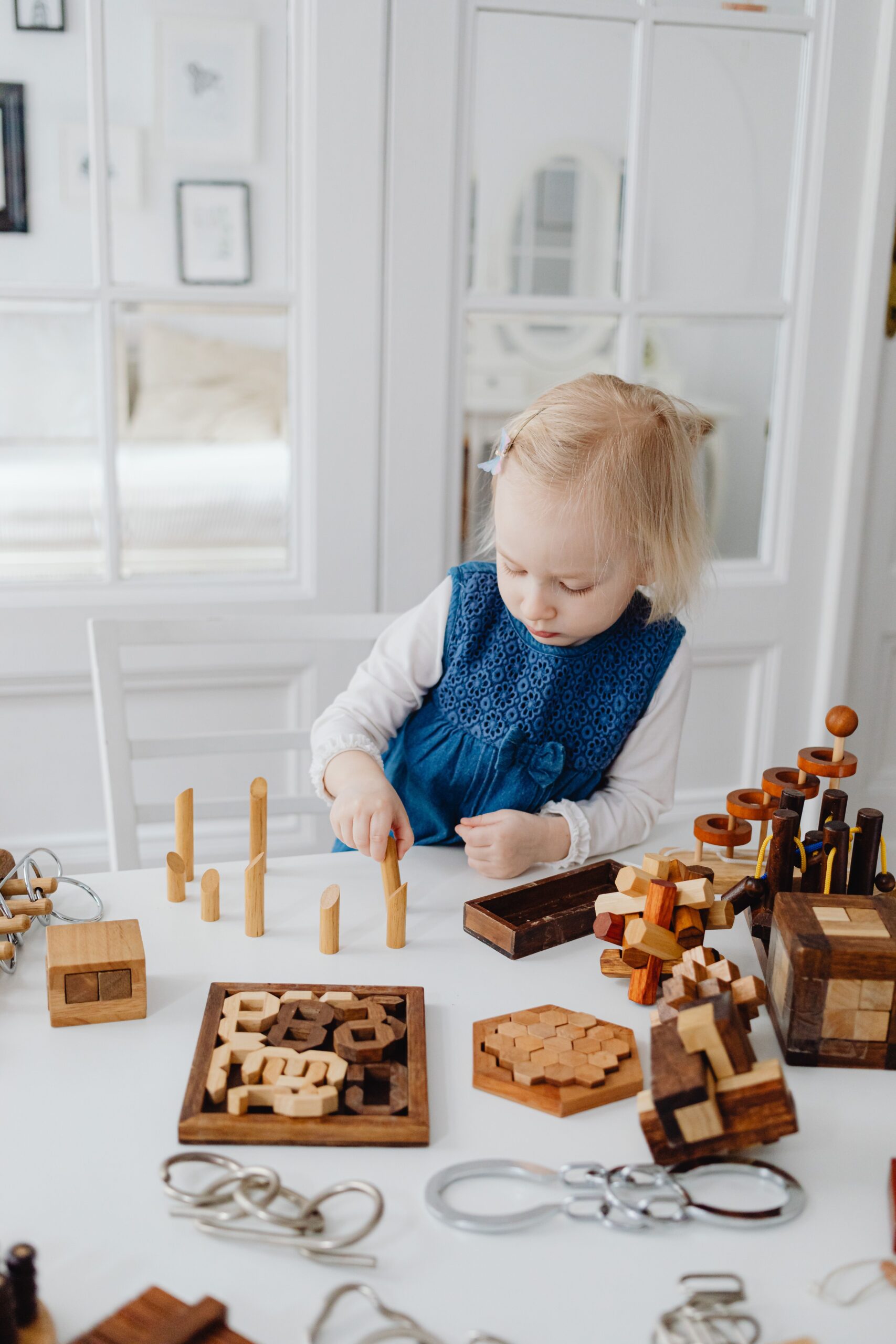 Montessori practical life toys for toddlers: a toddler working with wooden puzzles for fine motor skills