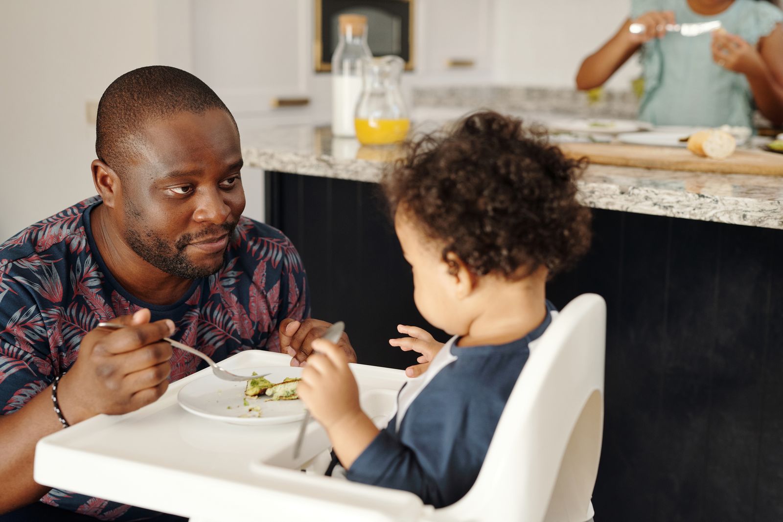 Parent calmly feeding a toddler, a key part of how to stop toddler from throwing food