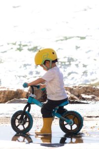 What age is a balance bike for: toddler riding a 12 inch balance bike outdoors