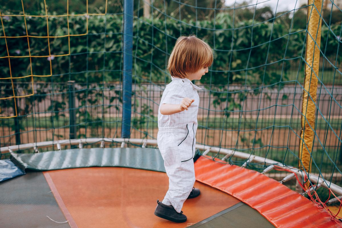 Trampoline for toddlers age 2-5: a young child jumping on an outdoor trampoline