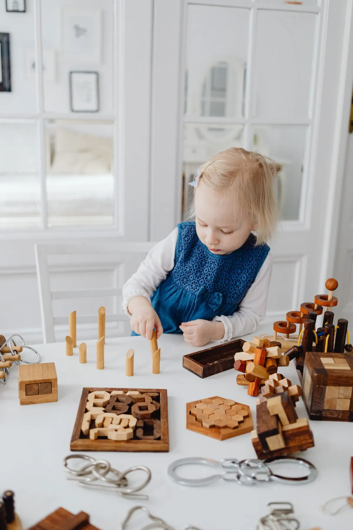 Montessori practical life toys for toddlers: a toddler working with wooden puzzles for fine motor skills
