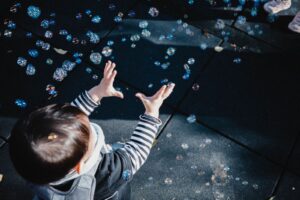Toddler chasing bubbles outside, one of the easiest outdoor activities for toddlers