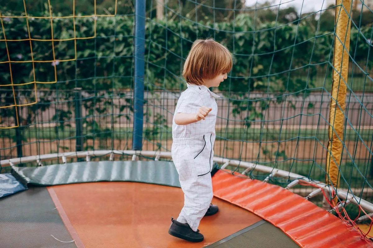 Trampoline for toddlers age 2-5: a young child jumping on an outdoor trampoline