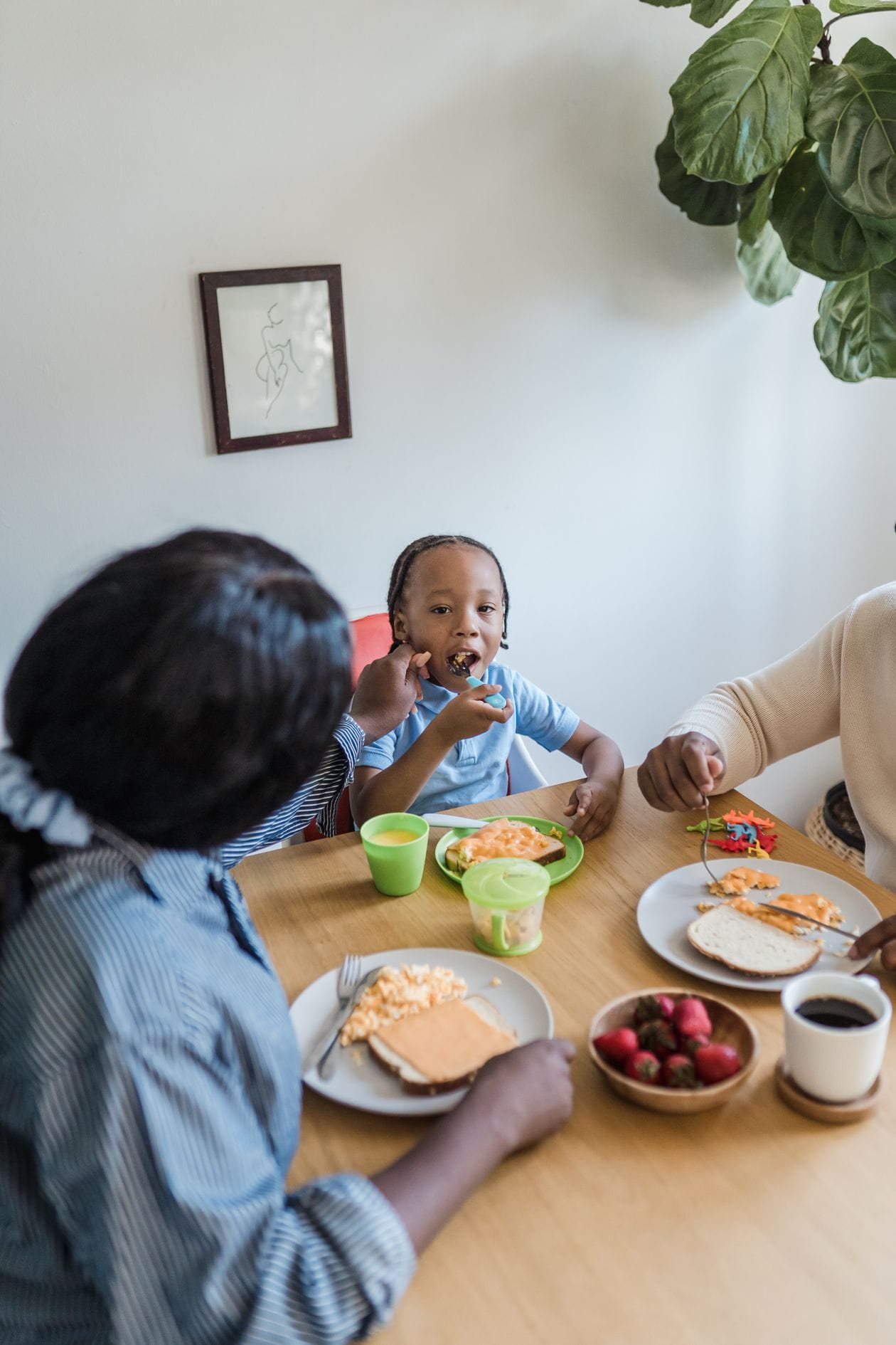 Toddler eating one of several dairy free meals for toddlers 2 year old with family at the table